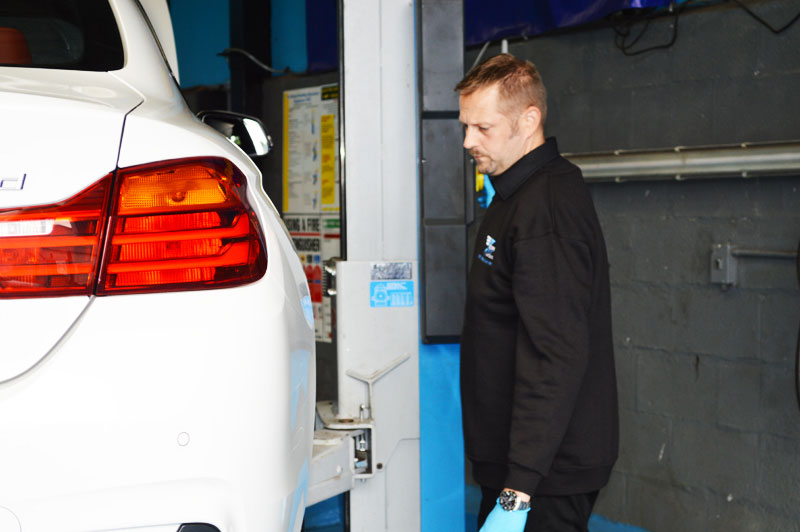 Mechanic checking car in garage