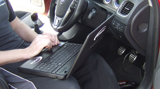 Mechanic on laptop inside of car