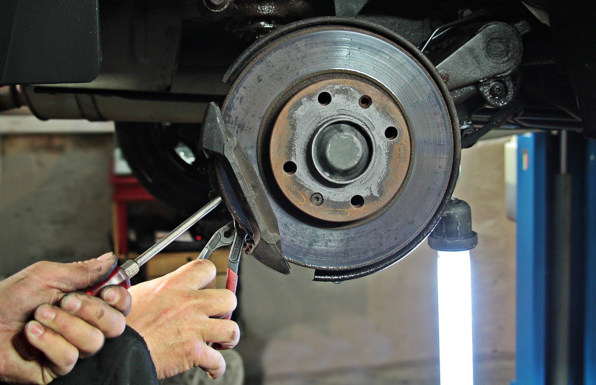 Close up of mechanic fixing car brake